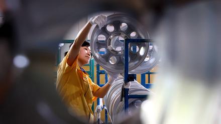 Ein Arbeiter produziert eine Radnabe in einer Werkstatt eines Autoradherstellers in Binzhou, China.