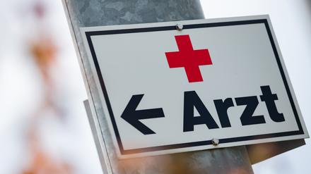 Ein Schild mit der Aufschrift «Arzt» hängt an einer Straßenlaterne.