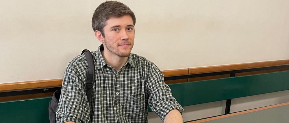 Klimaaktivist Henning Jeschke sitzt festgeklebt an einem Tisch in einem Raum des Amtsgericht Tiergarten.