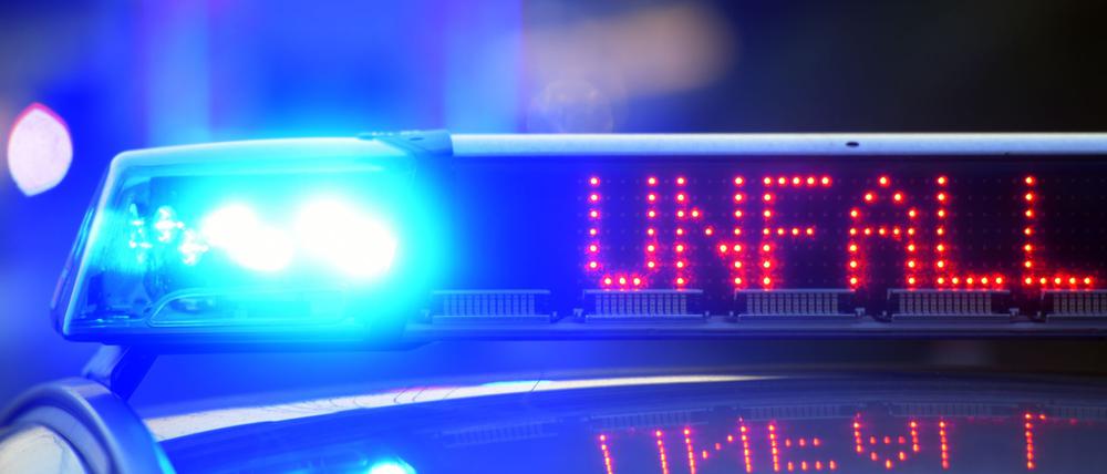 Auf einem Polizeifahrzeug warnt eine Leuchtschrift vor einer Unfallstelle.
