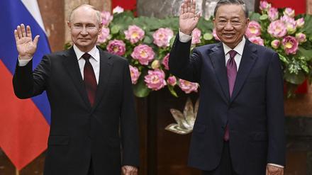 Der russische Präsident Wladimir Putin (l) und der vietnamesische Präsident To Lam winken im Präsidentenpalast. 
