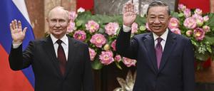 Der russische Präsident Wladimir Putin (l) und der vietnamesische Präsident To Lam winken im Präsidentenpalast. 