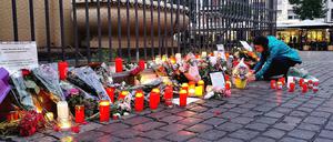 Nach dem Bekanntwerden vom Tod des Polizisten legen am Tatort am Marktplatz Passanten Blumen nieder und zünden Kerzen an. Der Polizist war hier von einem Mann mit einem Messer niedergestochen und lebensgefährlich verletzt worden.