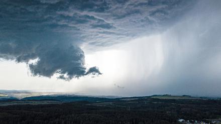 Eine Unwetterfront aus dunkelgrauen Wolken zieht über Dittersdorf in Thüringen.