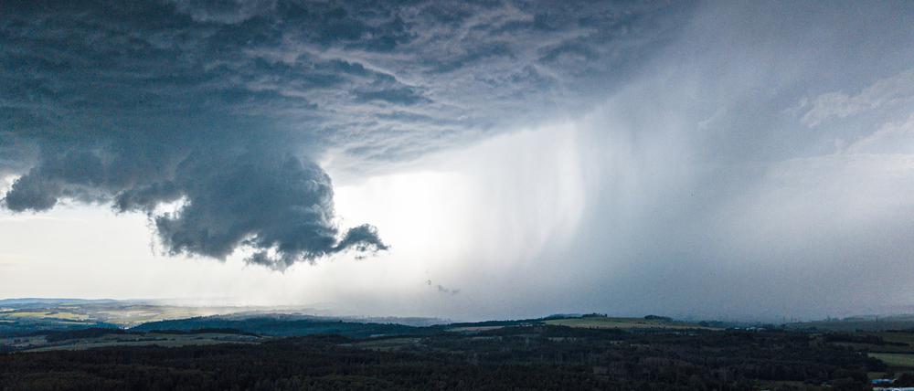 Eine Unwetterfront aus dunkelgrauen Wolken zieht über Dittersdorf in Thüringen.