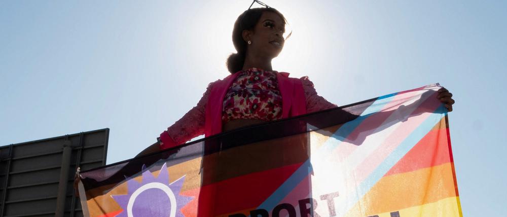 Eine Person hält eine Regenbogenflagge in Windhoek. 