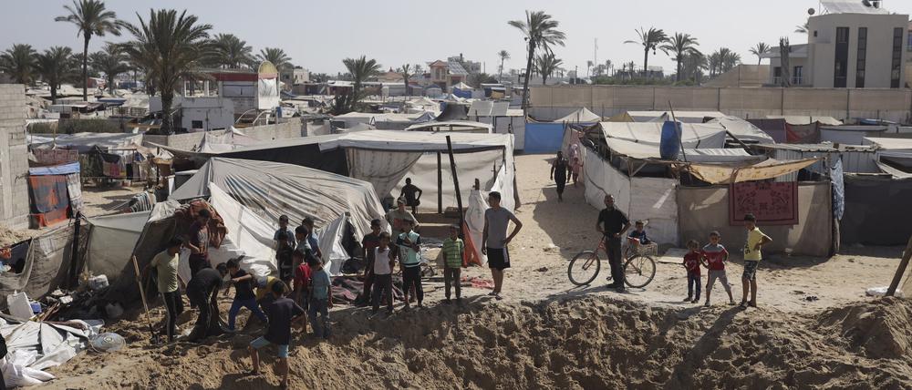Palästinenser versammeln sich am Rande eines Kraters nach einem israelischen Luftangriff in einem Gebiet, in dem Vertriebene im südlichen Gazastreifen Zuflucht gefunden haben.