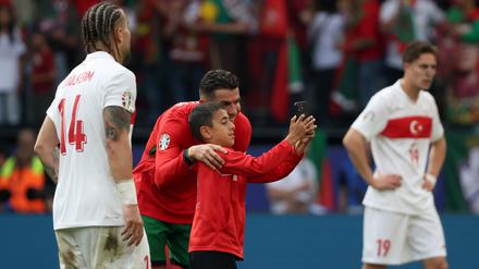 22.06.2024, Nordrhein-Westfalen, Dortmund: Ein Junge, der als Flitzer auf das Spielfeld gerannt ist, macht mit Portugals Cristiano Ronaldo ein Selfie.