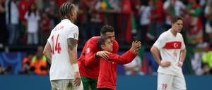 22.06.2024, Nordrhein-Westfalen, Dortmund: Ein Junge, der als Flitzer auf das Spielfeld gerannt ist, macht mit Portugals Cristiano Ronaldo ein Selfie.