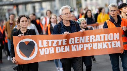 Demonstranten der Klimagruppe „Letzte Generation“ laufen mit einem Banner mit der Aufschrift „Letzte Generation vor den Kipppunkten“ durch Berlin-Mitte. (Archivbild aus dem August 2023)