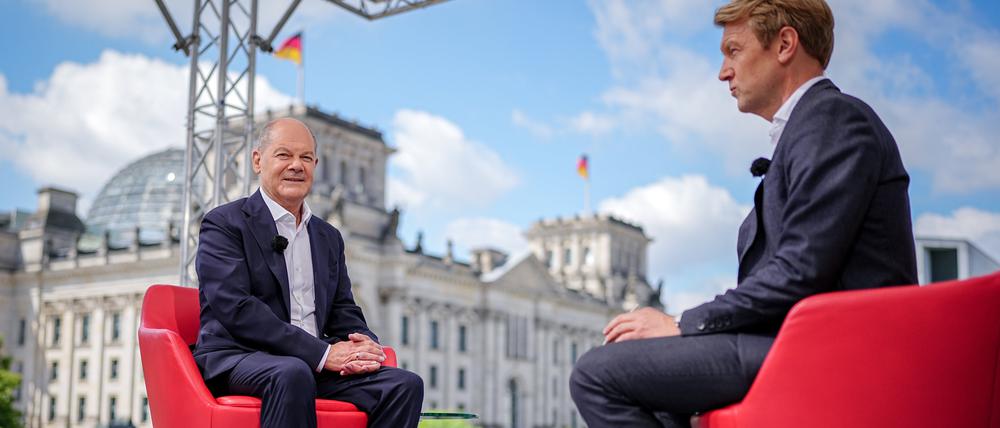 Bundeskanzler Olaf Scholz (SPD) sitzt zu Beginn des ARD-Sommerinterviews im „Bericht aus Berlin“ bei Markus Preiß (r), Leiter des ARD-Hauptstadtstudios.