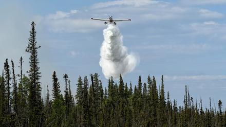 Ein Flugzeug wirft Wasser auf die Feuerlinie von Fort Good Hope in den Northwest Territories (Symbolbild).