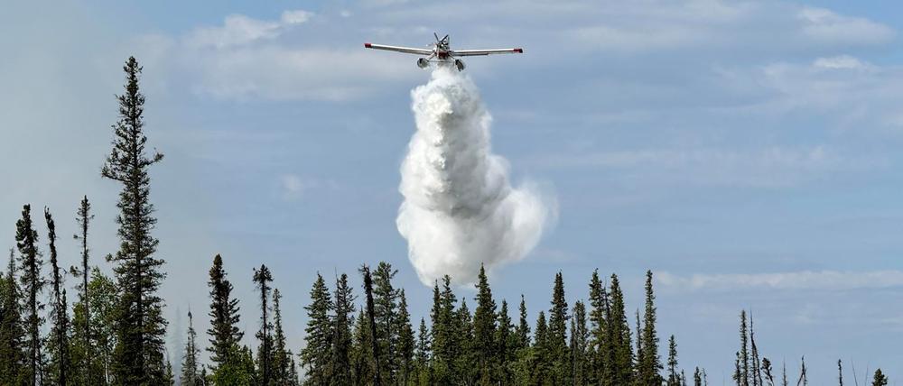 Ein Flugzeug wirft Wasser auf die Feuerlinie von Fort Good Hope in den Northwest Territories (Symbolbild).