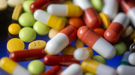 Verschiedene Tabletten, Kapseln und Dragees liegen auf einem Tisch.