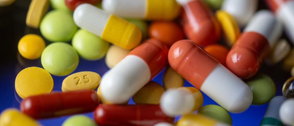 Verschiedene Tabletten, Kapseln und Dragees liegen auf einem Tisch.
