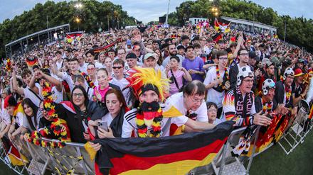 Deutsche Fans feuern ausgelassen die Mannschaft an und halten einen Pokal in die Höhe. Berlin Deutschland 