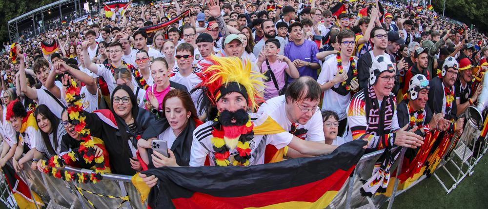Deutsche Fans feuern ausgelassen die Mannschaft an und halten einen Pokal in die Höhe. Berlin Deutschland 