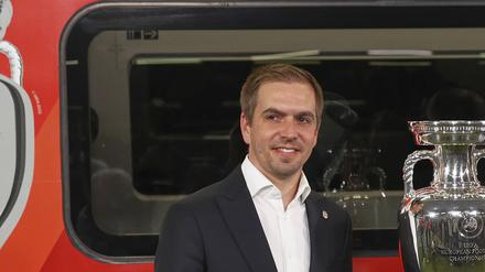 EM-Botschafter Philipp Lahm (l.-r.), DB-Chef Richard Lutz und Volker Wissing (FDP), Bundesverkehrsminister, stehen bei der Bekanntgabe der Partnerschaft zwischen Deutscher Bahn (DB) und der UEFA zur Europameisterschaft 2024 vor dem originalen EM-Pokal und einem entsprechend gestalteten ICE. (Archivbild)