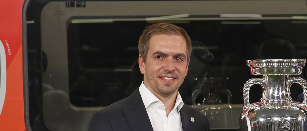 EM-Botschafter Philipp Lahm (l.-r.), DB-Chef Richard Lutz und Volker Wissing (FDP), Bundesverkehrsminister, stehen bei der Bekanntgabe der Partnerschaft zwischen Deutscher Bahn (DB) und der UEFA zur Europameisterschaft 2024 vor dem originalen EM-Pokal und einem entsprechend gestalteten ICE. (Archivbild)