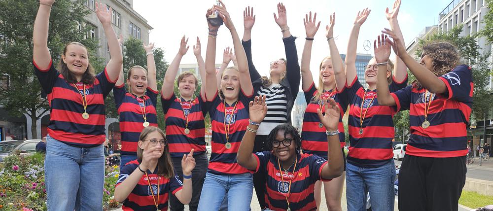 Die zehn Schöneberger Rugby-Meisterinnen und Berlins Bildungsstaatssekretärin Christina Henke feiern den Sieg am Wittenbergplatz.