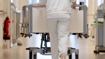 Eine Krankenpflegerin schiebt ein Krankenbett durch einen Krankenhausflur. (Symbolbild)
