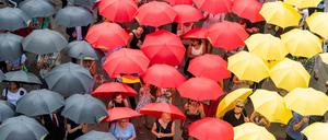 Eingebürgerte Menschen stehen mit schwarz-rot-goldenen Regenschirmen nach dem Einbürgerungsfest vor dem sächsischen Landtag (Symbolbild).