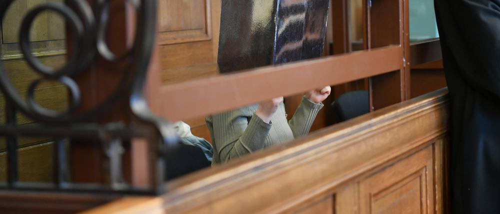 Eine Frau sitzt im Kriminalgericht Moabit auf einer Bank in einem Gerichtssaal. Der 42-jährigen Frau wird Totschlag sowie Tötung auf Verlangen vorgeworfen, einem ebenfalls angeklagten 71-jährigen Mann Totschlag durch Unterlassen. Die Frau soll am 13. Oktober 2023 in Berlin-Köpenick zunächst ihre Tochter umgebracht haben. Dann soll sie ihre 68 Jahre alte Mutter auf deren ausdrückliches Verlangen getötet haben. 