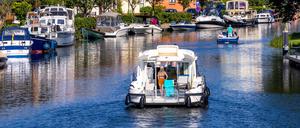 25.06.2024, Mecklenburg-Vorpommern, Plau am See: Eine Motoryacht fährt aus der Schleuse in die Elde und weiter in die Mecklenburgische Seenplatte. Mit dem Ferienbeginn in Niedersachsen startet die Tourismus-Hochsaison in den Urlaubsgebieten von Mecklenburg-Vorpommern. Foto: Jens Büttner/dpa +++ dpa-Bildfunk +++