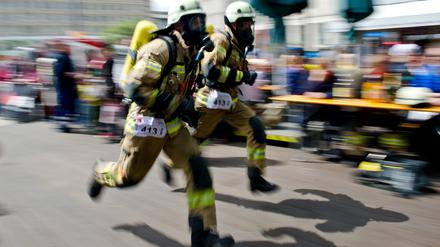 Feuerwehrmänner rennen beim Berliner Firefighter Stairrun in Richtung des Park Inn Hotels in Berlin.