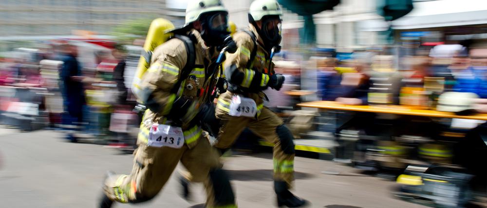 Feuerwehrmänner rennen beim Berliner Firefighter Stairrun in Richtung des Park Inn Hotels in Berlin.