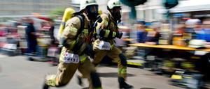 Feuerwehrmänner rennen beim Berliner Firefighter Stairrun in Richtung des Park Inn Hotels in Berlin.