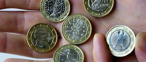 Eine junge Frau begutachtet am Dienstag die in ihrer Hand liegenden Euro-Münzen aus Frankreich (v.l. oben nach r. unten), Griechenland, Österreich, Portugal, Italien und Deutschland. 