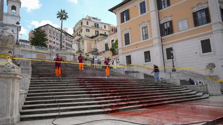26.06.2024, Italien, Rom: Arbeiter der Stadt Rom reinigen die Spanische Treppe, nachdem Aktivisten sie mit roter Farbe beschmiert haben, um gegen Gewalt an Frauen zu protestieren. Foto: Andrew Medichini/AP/dpa +++ dpa-Bildfunk +++