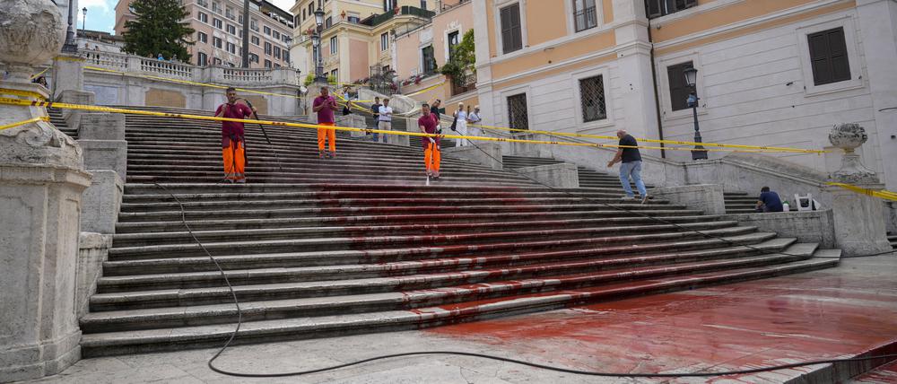 26.06.2024, Italien, Rom: Arbeiter der Stadt Rom reinigen die Spanische Treppe, nachdem Aktivisten sie mit roter Farbe beschmiert haben, um gegen Gewalt an Frauen zu protestieren. Foto: Andrew Medichini/AP/dpa +++ dpa-Bildfunk +++