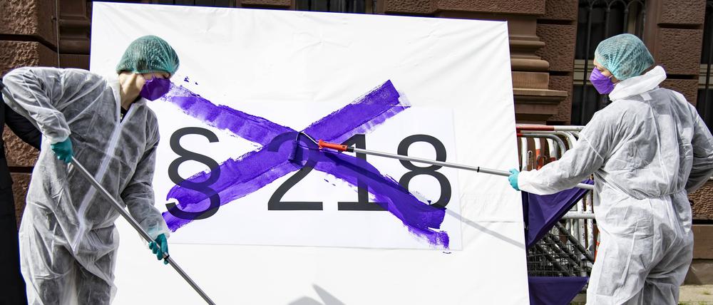 Für das Recht auf einen Schwangerschaftsabbruch: Aktivistinnen streichen während eines Flashmobs mit der Farbe Lila symbolisch den Paragraf 218 aus dem Strafgesetzbuch durch.