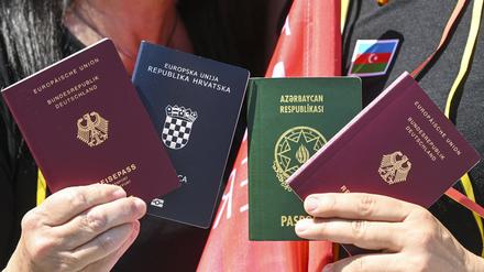 Menschen zeigen bei einem Fototermin zur Unterstützung des neuen Staatsangehörigkeitsrecht zwei Pässe: den deutschen und den kroatischen (links) sowie den deutschen und aserbaidschanischen. 