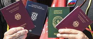 Menschen zeigen bei einem Fototermin zur Unterstützung des neuen Staatsangehörigkeitsrecht zwei Pässe: den deutschen und den kroatischen (links) sowie den deutschen und aserbaidschanischen. 