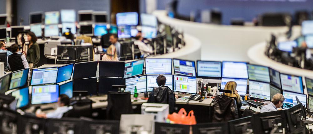 Händlerinnen und Händler sitzen im Handelssaal der Frankfurter Börse vor ihren Monitoren.