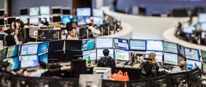Händlerinnen und Händler sitzen im Handelssaal der Frankfurter Börse vor ihren Monitoren.