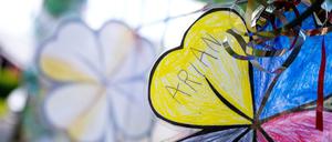Gebastelte vierblättrige Kleeblätter mit der Aufschrift „Arian“ hängen an einem Zaun im Wohnort von Arians Familie. 