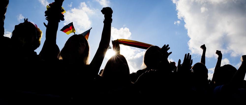 Fußballfans im Gegenlicht.