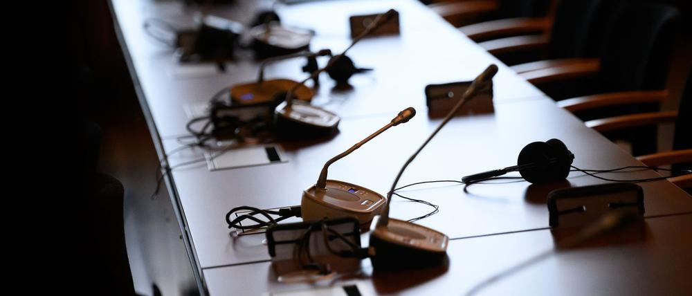Mikrofone und Kopfhörer auf einem Tisch in einem Gerichtssaal.