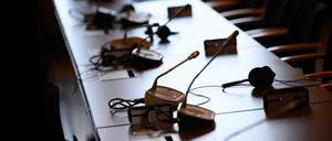 Mikrofone und Kopfhörer auf einem Tisch in einem Gerichtssaal.