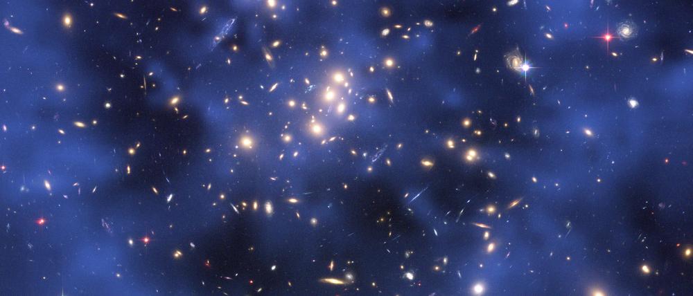 Sichtbar gemacht, was unsichtbar ist: Ein bläulicher Ring Dunkler Materie in einem fünf Milliarden Lichtjahre entfernten Galaxienhaufen im Sternbild Fische.