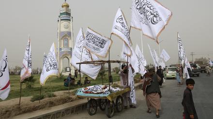 Afghanen in Kandahar verkaufen während einer Feier zum zweiten Jahrestag des Abzugs der US-amerikanischen Truppen Taliban-Fahnen an Passanten.