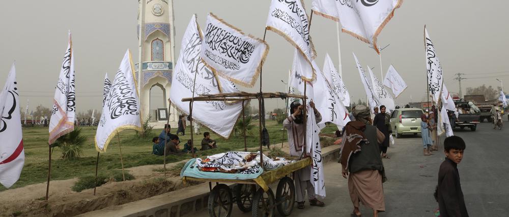 Afghanen in Kandahar verkaufen während einer Feier zum zweiten Jahrestag des Abzugs der US-amerikanischen Truppen Taliban-Fahnen an Passanten.