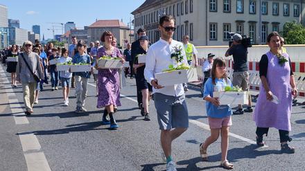 Kinder und Erwachsene tragen die Gebeine der ersten mittelalterlichen und frühneuzeitlichen Berlinerinnen und Berliner in kleinen Särgen von der Parochialkirche zum Petriplatz.