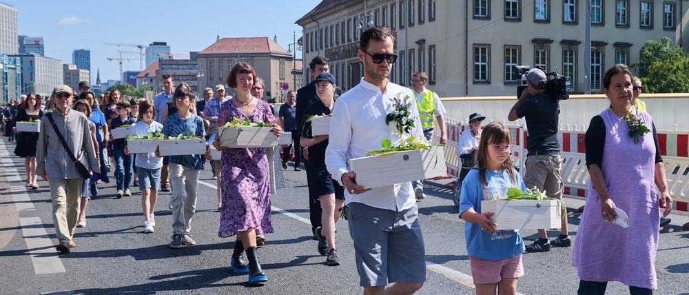 Kinder und Erwachsene tragen die Gebeine der ersten mittelalterlichen und frühneuzeitlichen Berlinerinnen und Berliner in kleinen Särgen von der Parochialkirche zum Petriplatz.