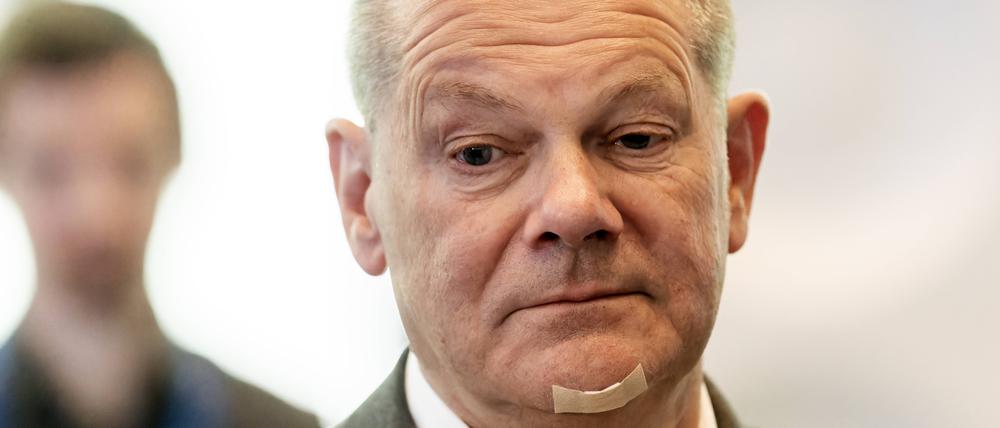 Ein nachdenklich blickender Kanzler Olaf Scholz (SPD) mit einem Pflaster am Kinn nach einem Rasierunfall.