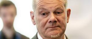Ein nachdenklich blickender Kanzler Olaf Scholz (SPD) mit einem Pflaster am Kinn nach einem Rasierunfall. 